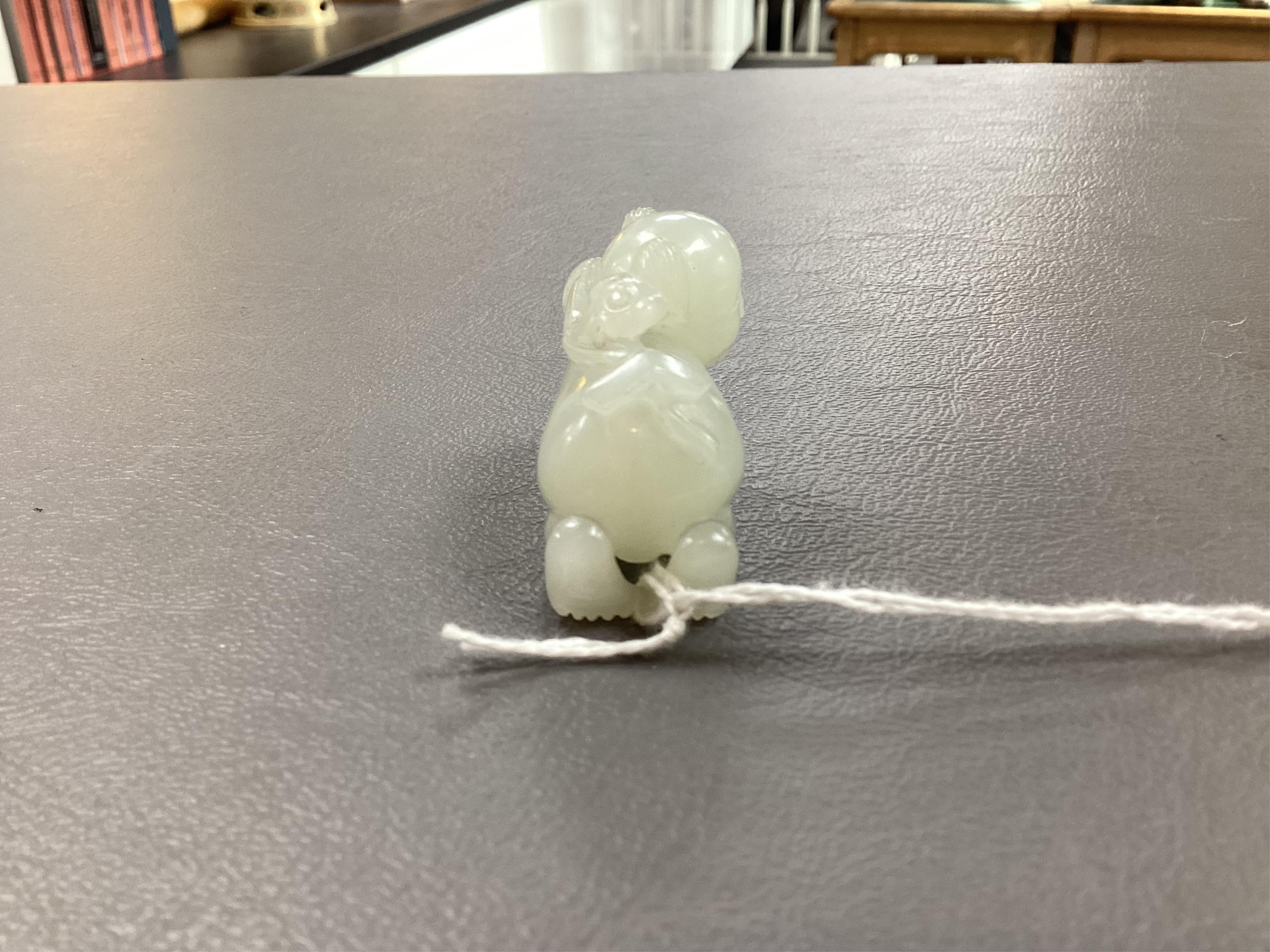 A Chinese white jade figure of a crouching boy, 19th/20th century